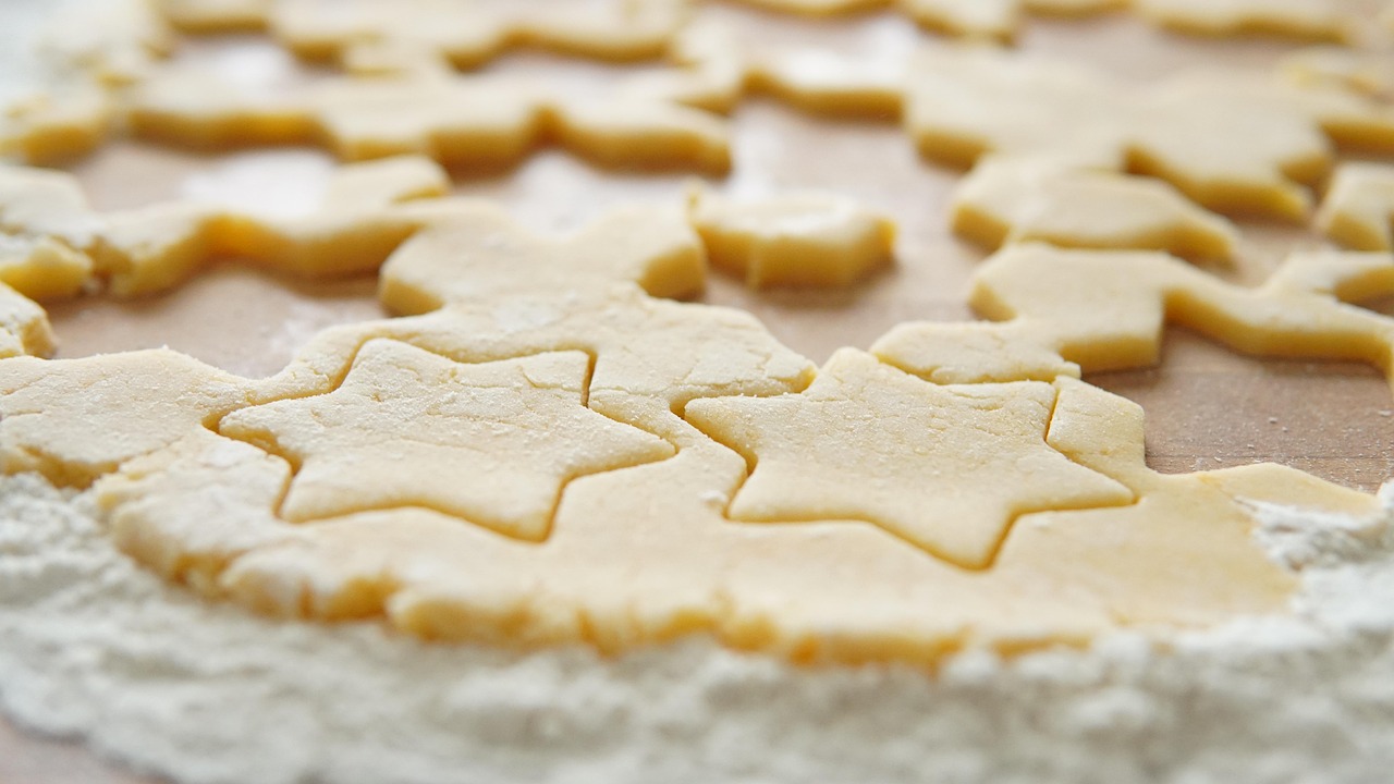 Star-shaped cookie dough cut-outs on a floured wooden board