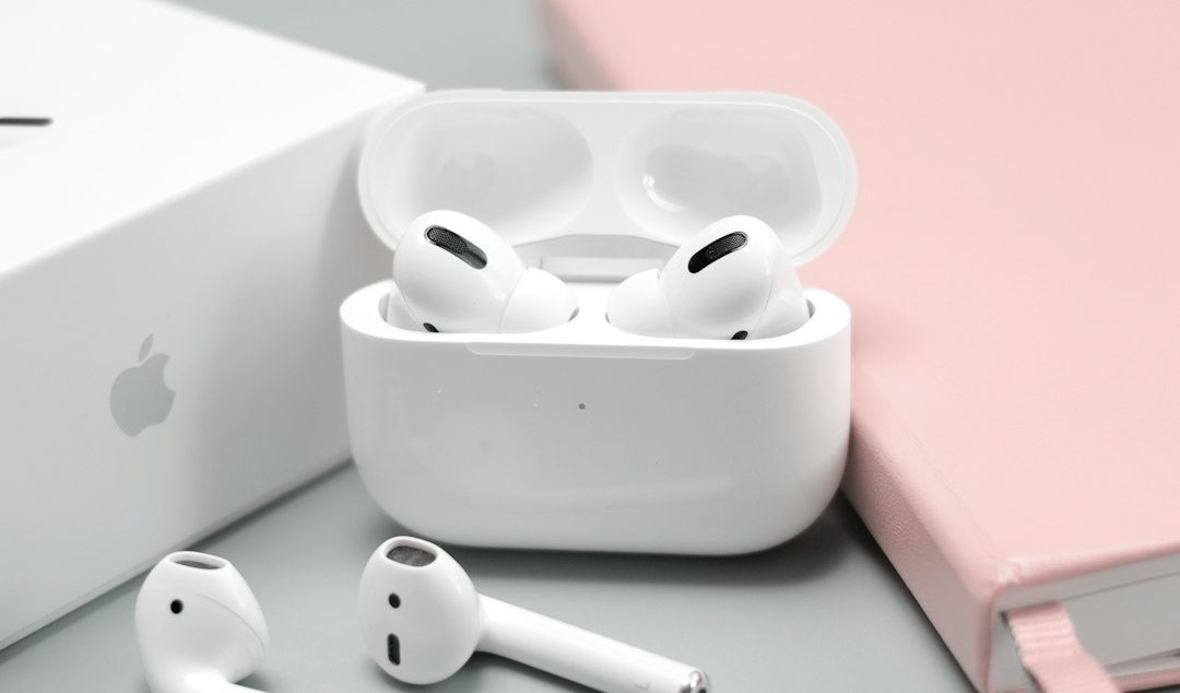 Open white charging case holding a pair of small wireless sleep earbuds