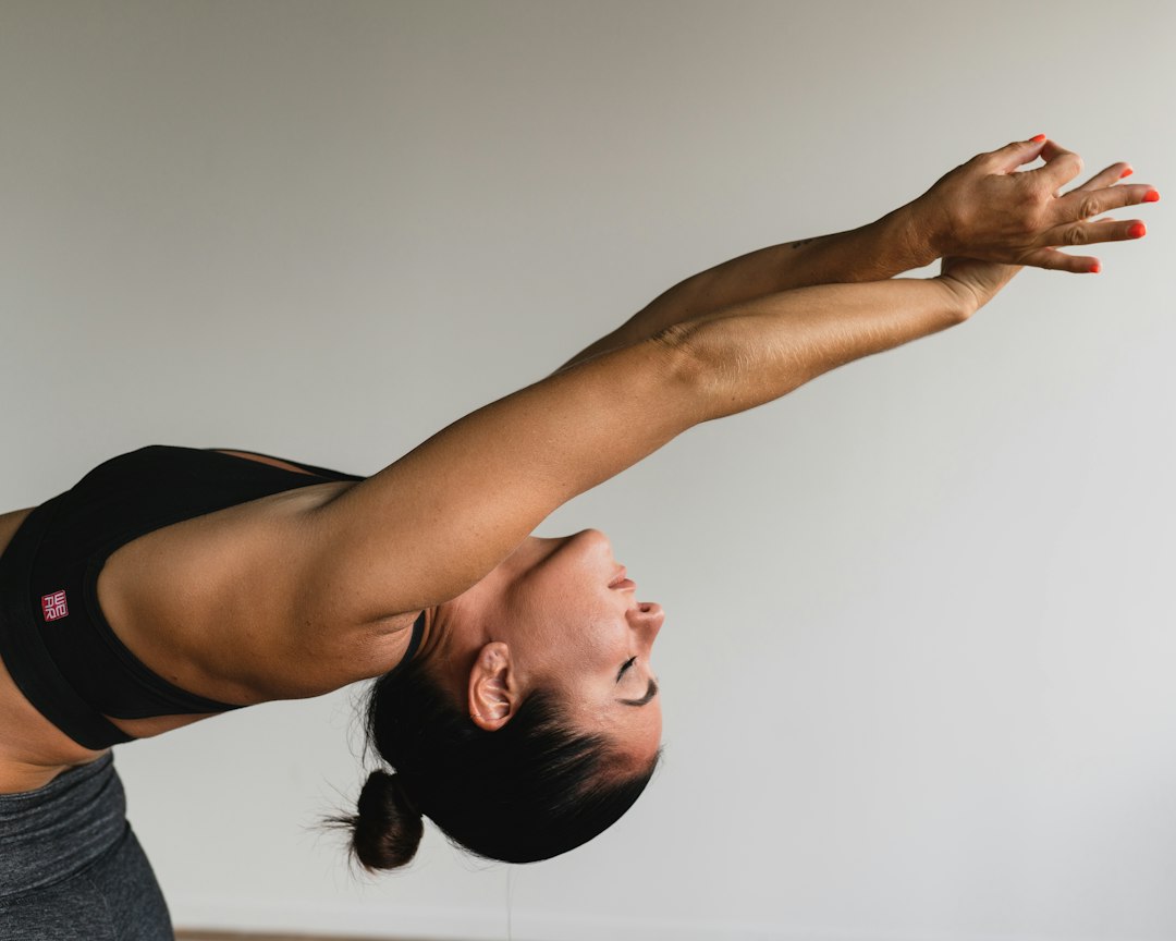 Woman in black activewear performing a deep backbend stretch