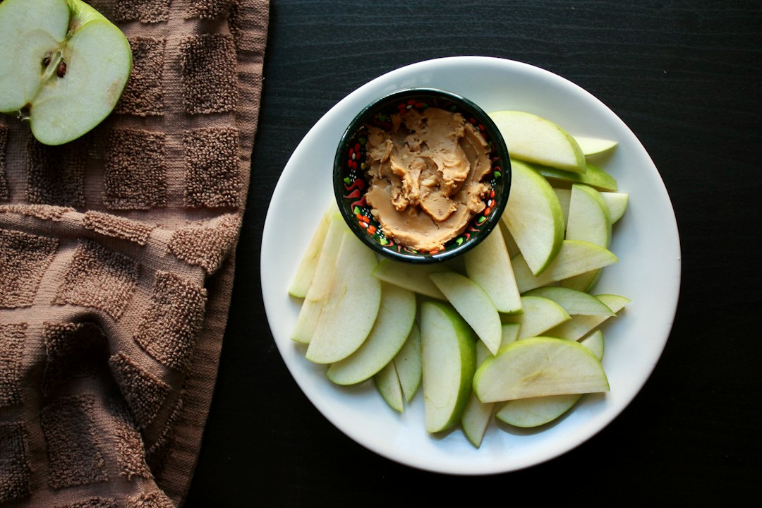 Sliced apples with a small bowl of peanut butter