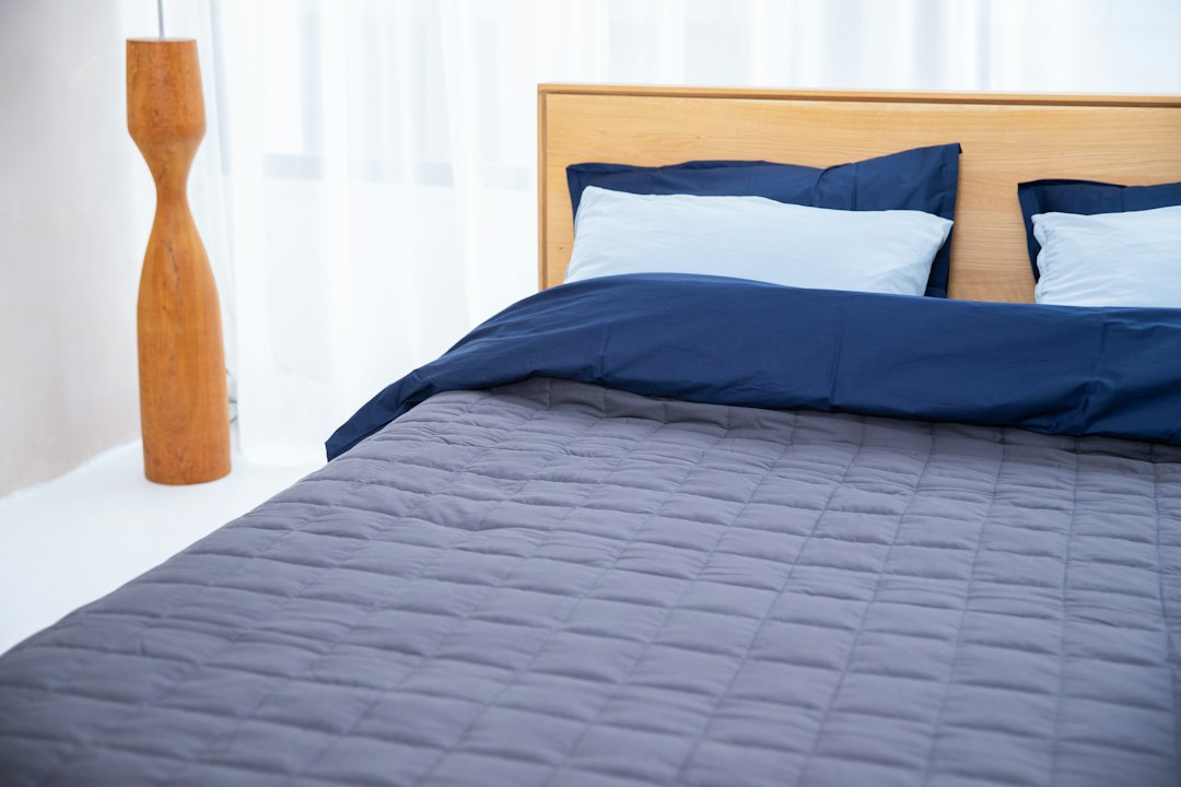 Neatly made bed in soft morning light, ready for a well-rested morning