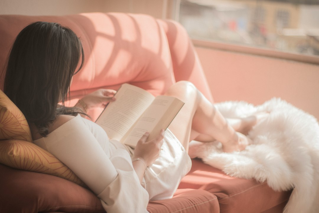 Woman relaxing and reading on a sofa in natural light