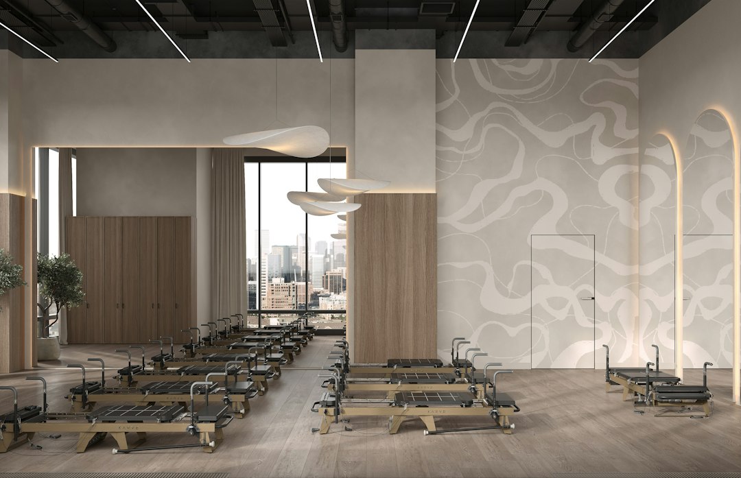 A bright Pilates studio with wooden reformer machines arranged in rows