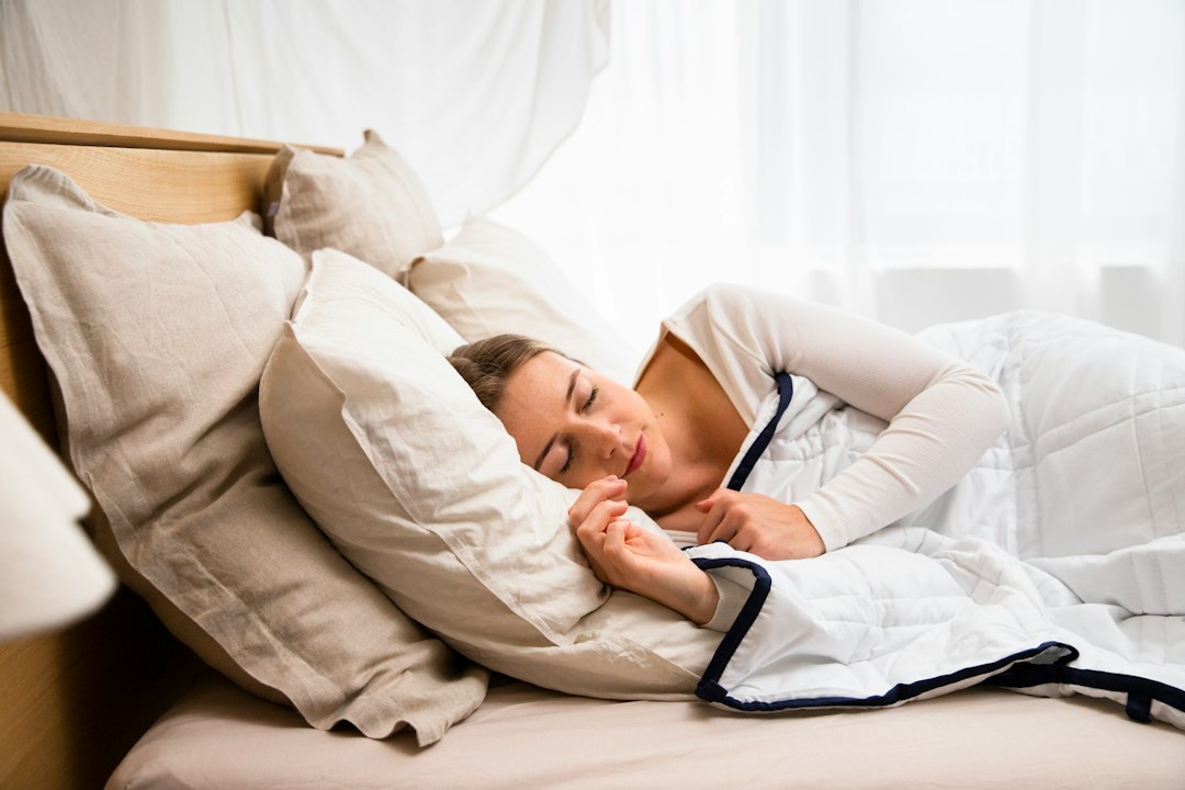Woman asleep in a quiet bedroom, the outcome a recovery ritual is supposed to earn