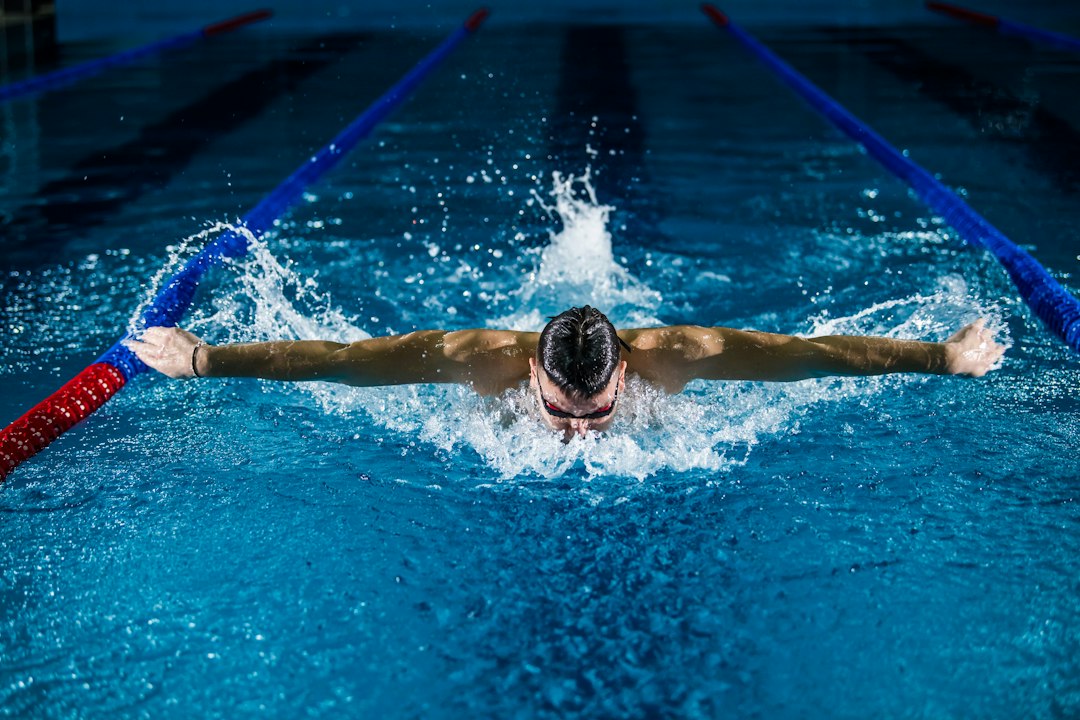 A swimmer powers through a lap in an indoor pool