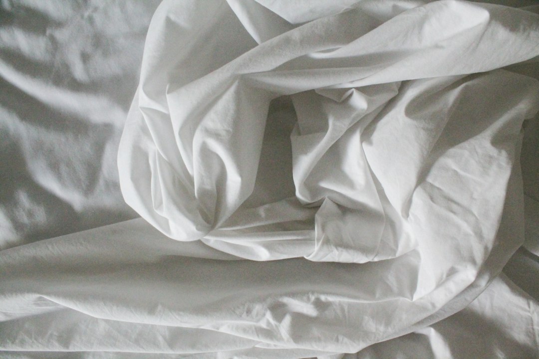 Soft white bedding rumpled from sleep