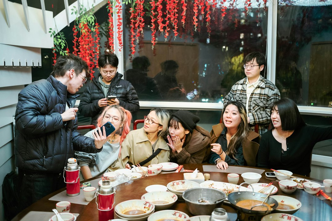 Group of friends laughing together over dinner at a restaurant table
