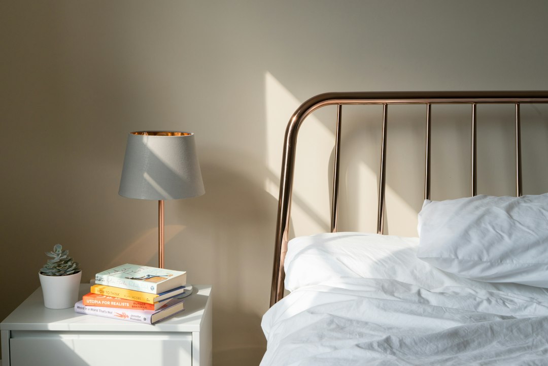 A sunlit bed and nightstand on a quiet morning