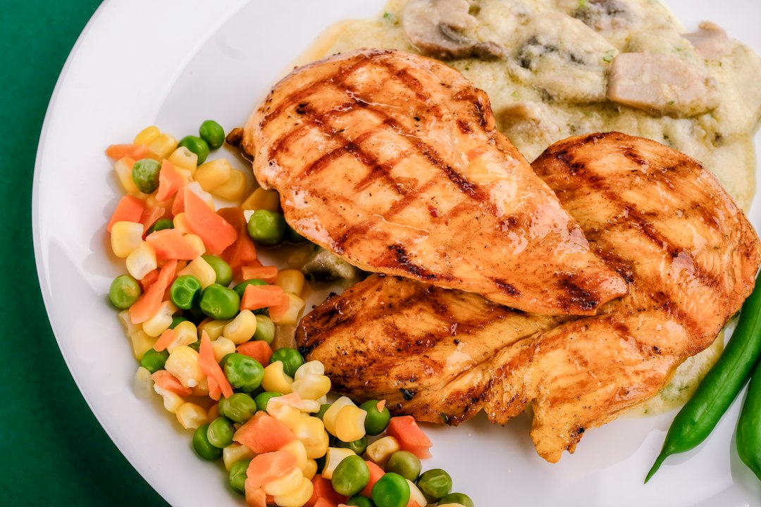 Grilled chicken with mixed vegetables on a white plate