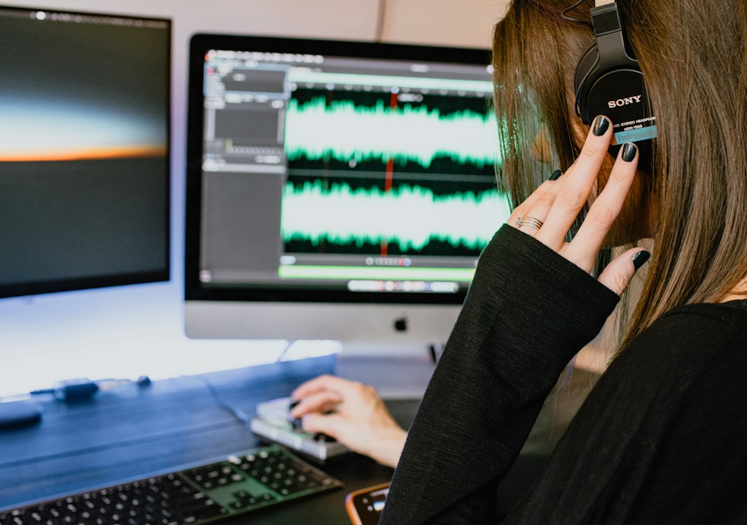 Woman wearing headphones while working with audio on a computer