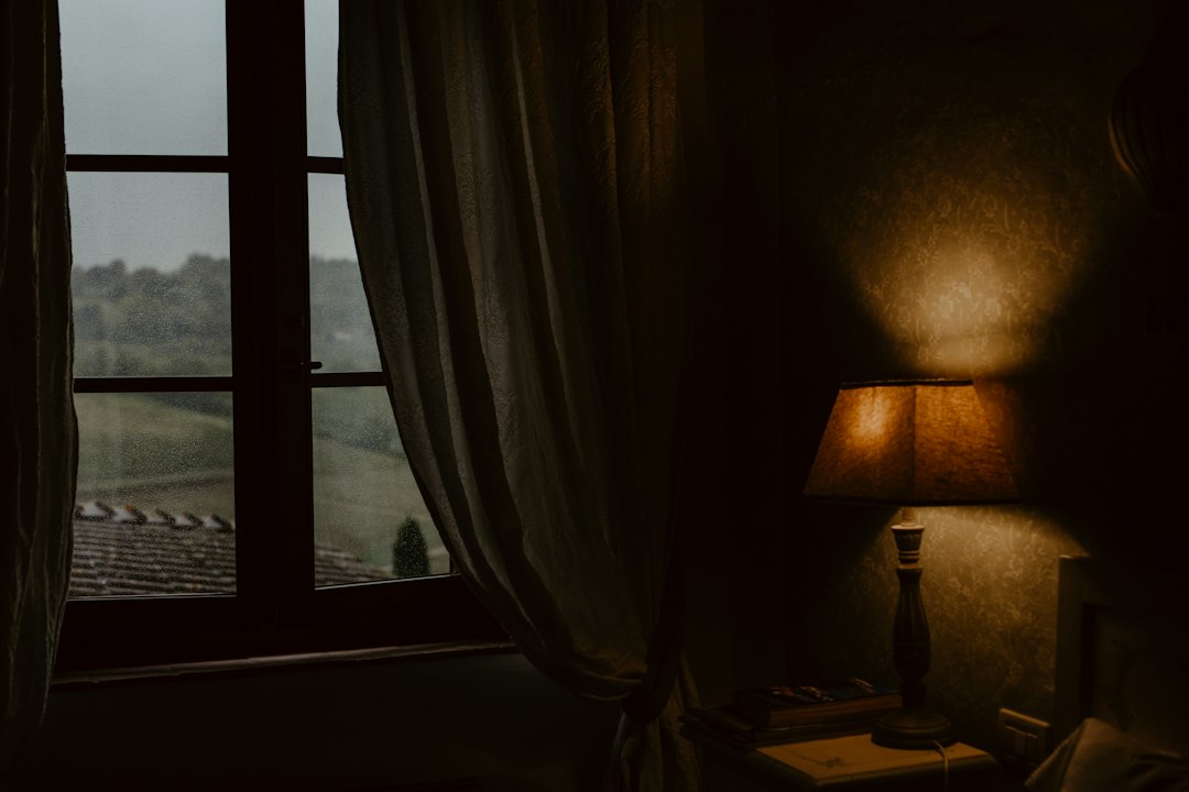 dimly lit cozy bedroom with a small lamp in the evening