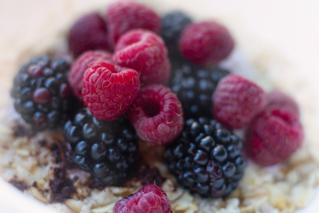 Bowl of oatmeal topped with fresh raspberries and blackberries