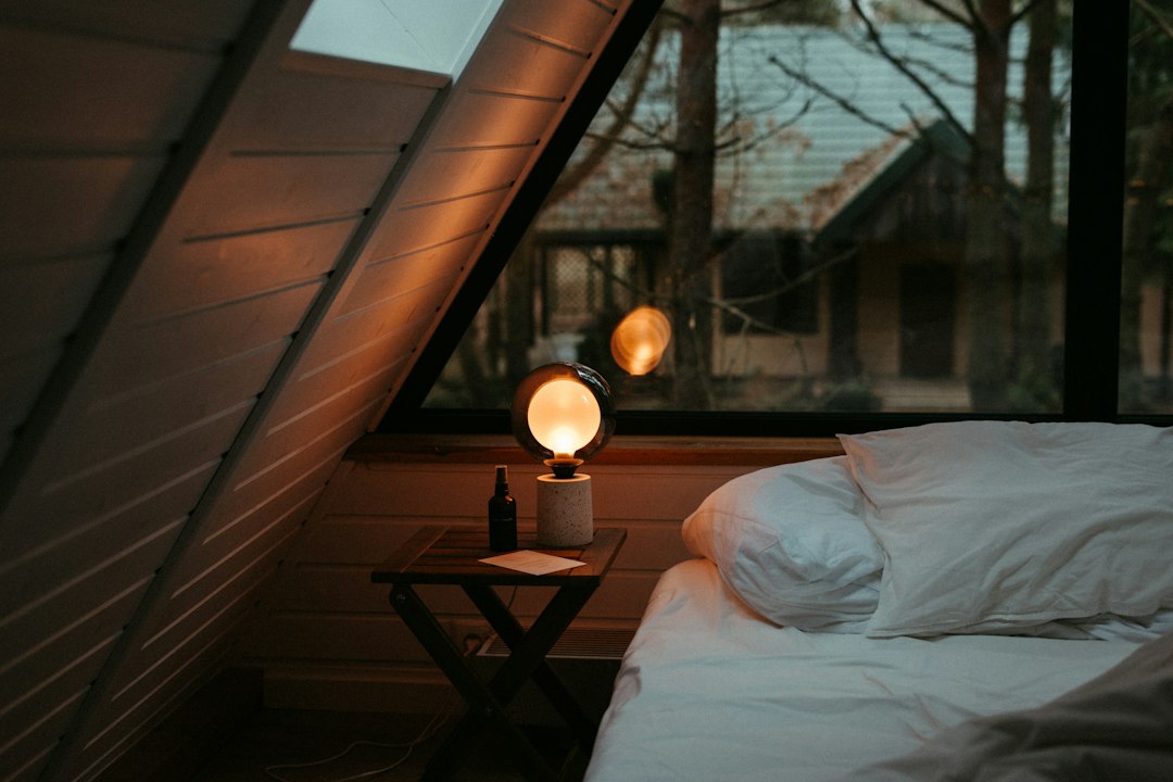 Cozy bedroom with a warm bedside lamp glowing in the evening