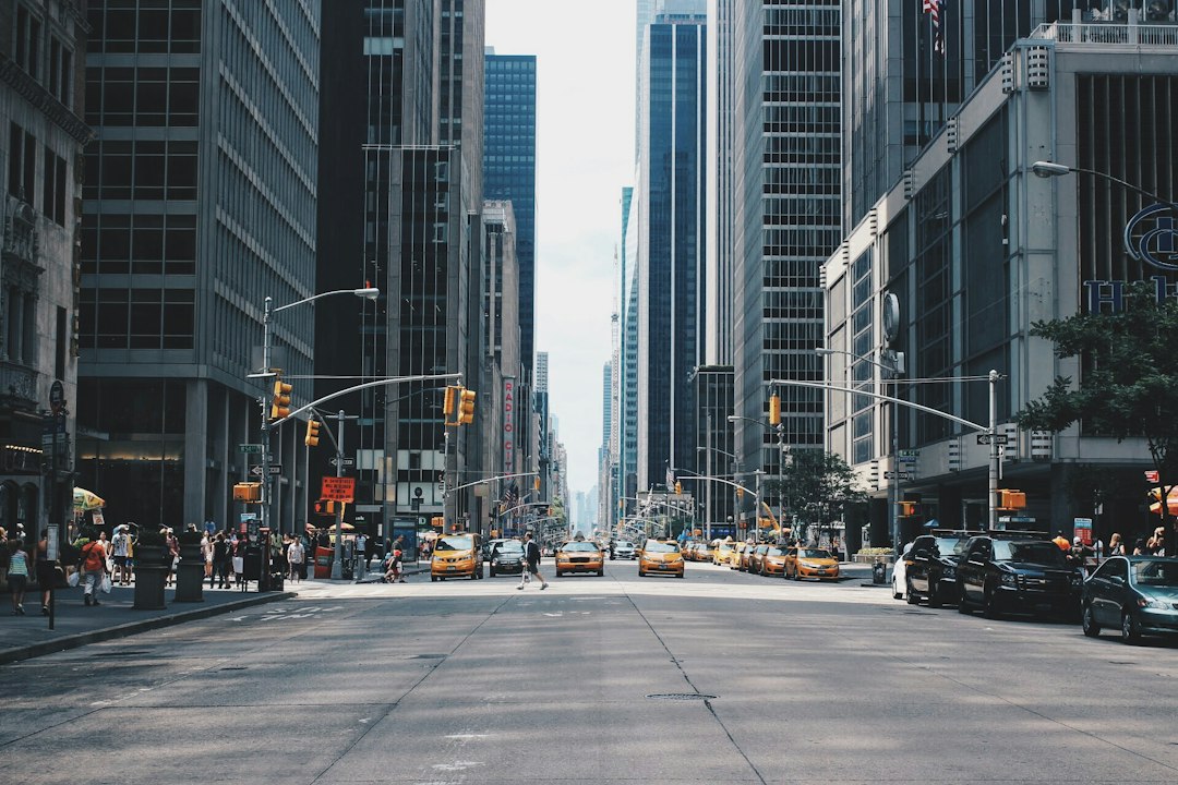 A runner moves along a city avenue with traffic in the background