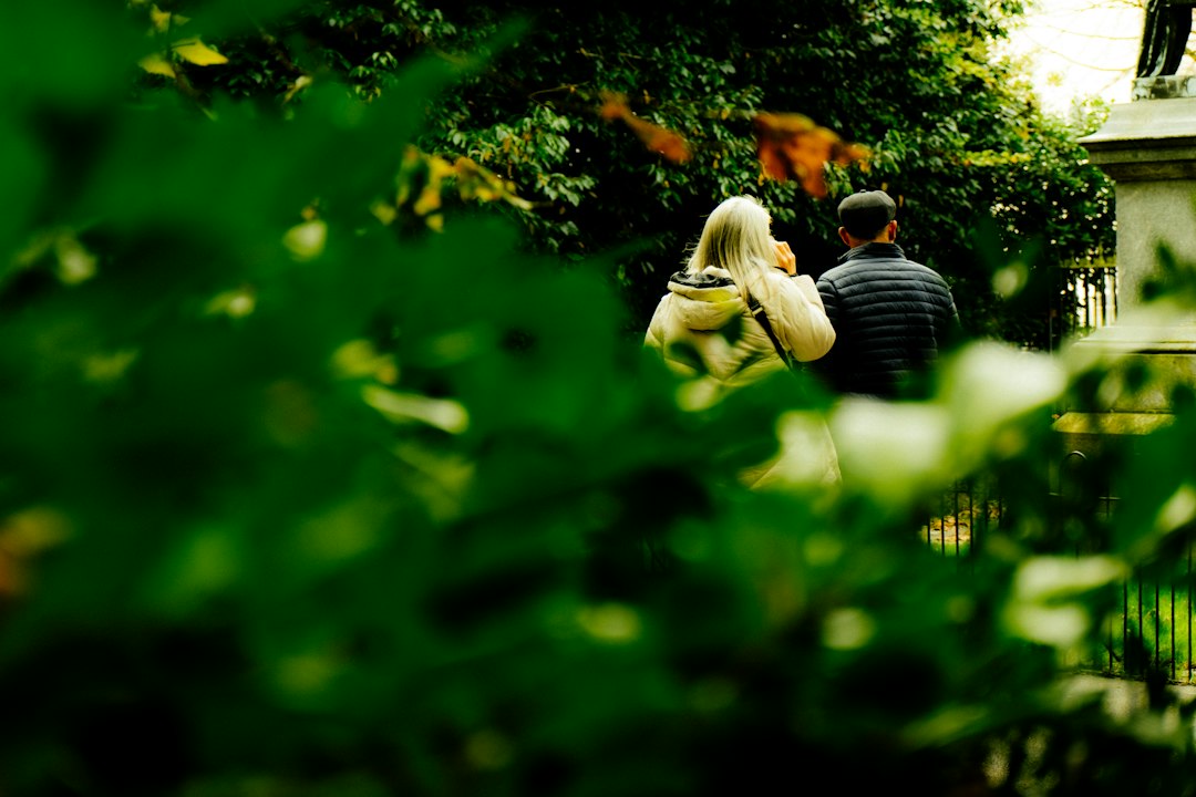 Two people walking a green path together outdoors