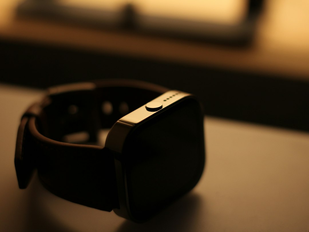 Smartwatch charging in dim evening light on a bedside surface